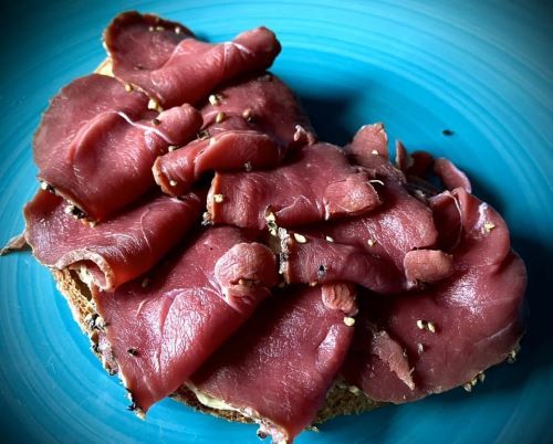 Erster Schritt: Scheiben vom Wildschwein-Pfefferschinken auf mit Trüffelbutter bestrichenem Bäckerbrot; Foto Heike 17.7.24